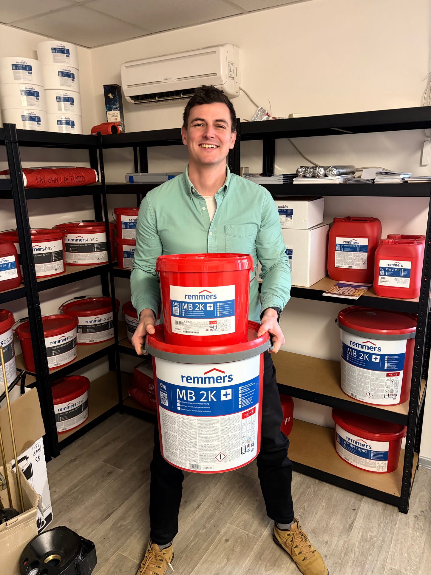 Kolega se snaží držet různé balení hybridní hydroizolační stěrky Remmers MB 2K
